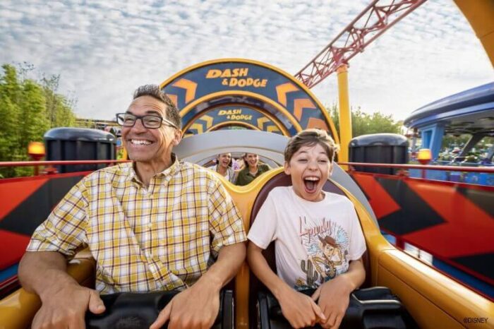 Dad and son riding Slinky Dog Dash ride at Disney's Hollywood Studios